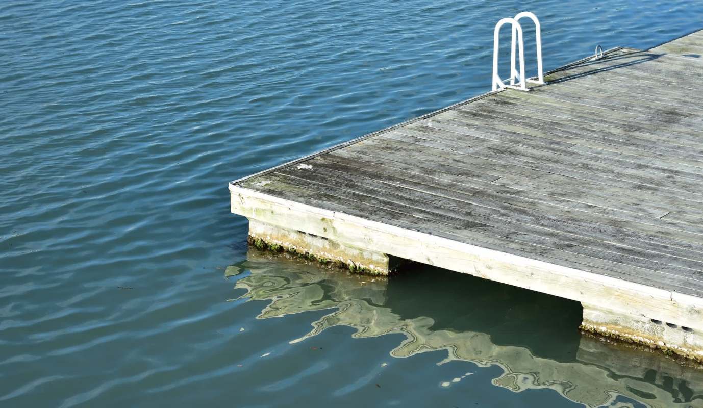 A wooden dock on calm water.