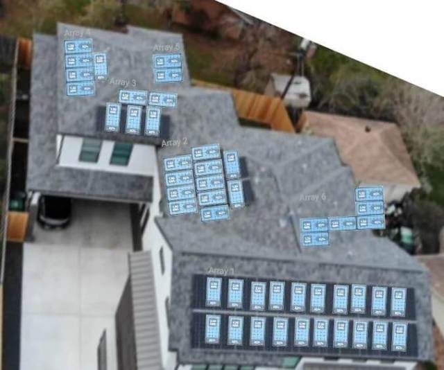 An aerial view of a home and solar panels.