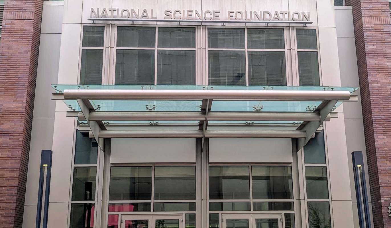 The entrance of the National Science Foundation building with modern architecture and glass canopy.