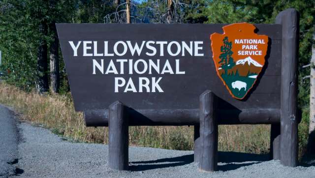 A large wooden sign for Yellowstone National Park.