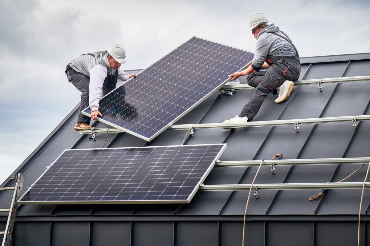 People installing solar panels on a roof.