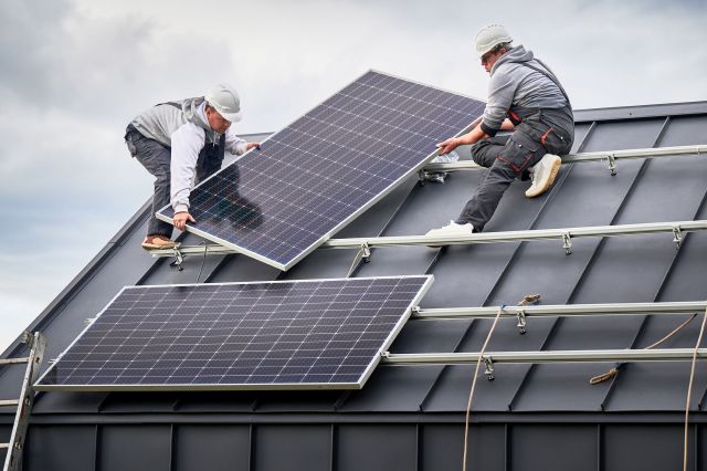 People installing solar panels on a roof.