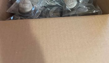 A partially open cardboard box containing individually packaged items.