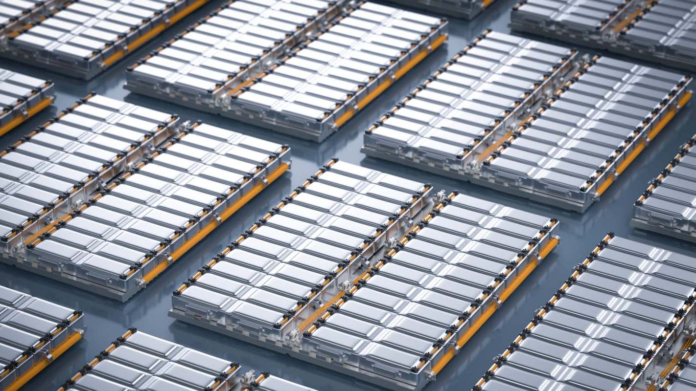 Aerial view of neatly arranged EV battery cells on a flat surface.