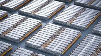 Aerial view of neatly arranged EV battery cells on a flat surface.