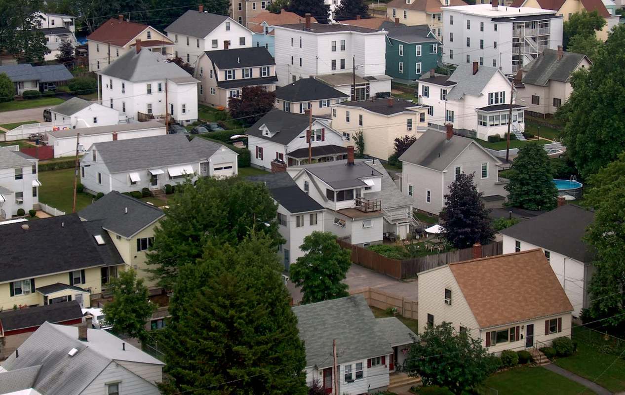 Aerial view of a suburban neighborhood with various houses and green trees.
