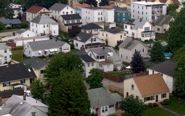 Aerial view of a suburban neighborhood with various houses and green trees.
