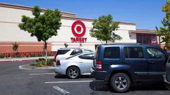 A parking lot in front of a Target store with several vehicles and shopping carts visible in the background.