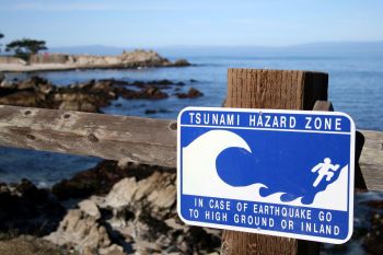 A tsunami warning sign advising people to head to higher ground or inland.