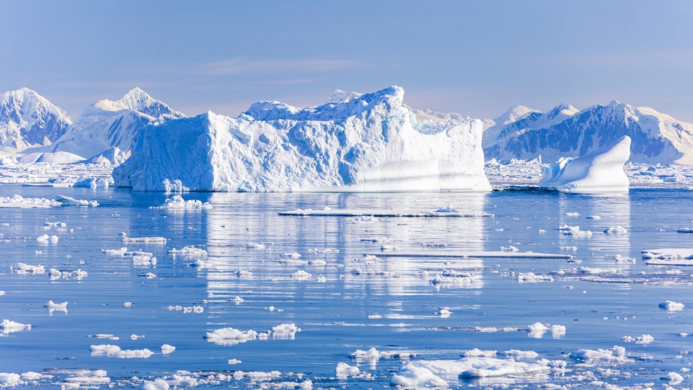 Icebergs and mountains on a clear day.