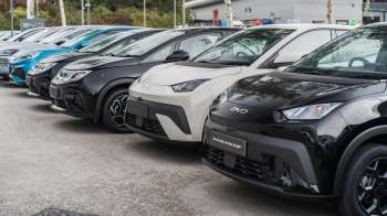 A row of various BYD electric cars displayed in an outdoor lot, featuring different colors and models.