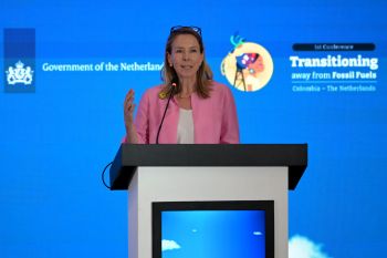 Dutch Climate Minister Stientje van Veldhoven, n a pink blazer, addresses an audience at a conference.