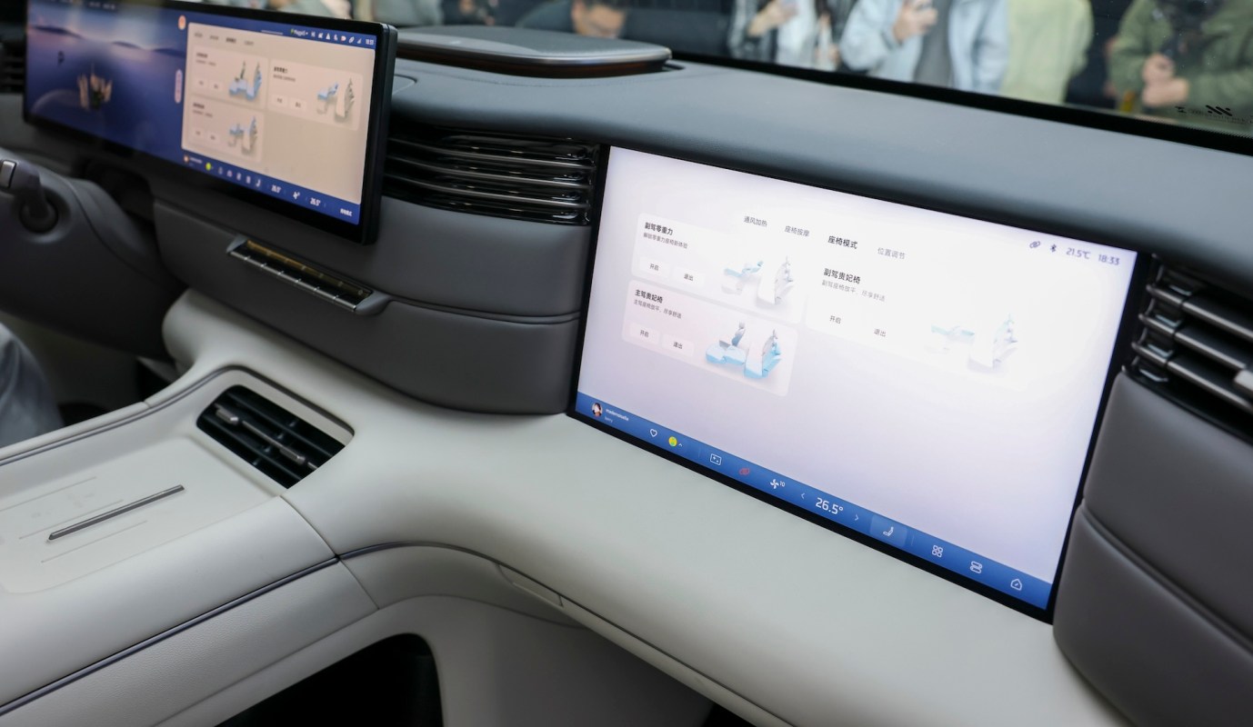 A modern car interior featuring large touchscreens displaying controls and information.