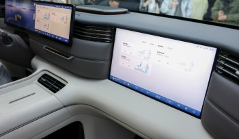 A modern car interior featuring large touchscreens displaying controls and information.
