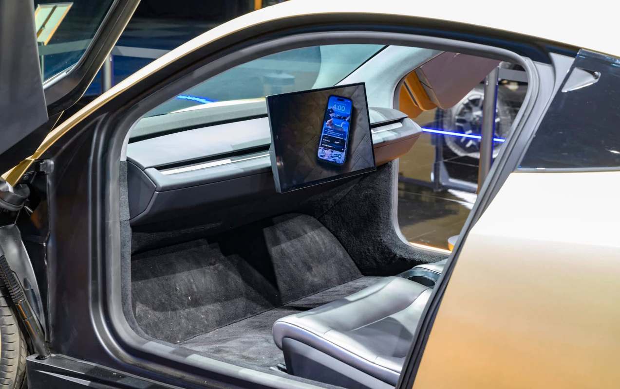 A Tesla Cybercab interior featuring a sleek design and a mounted digital display with no steering wheel.