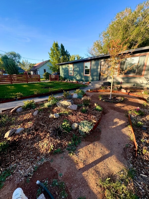 A revitalized yard featuring rocks, mulch, and drought-tolerant plants.