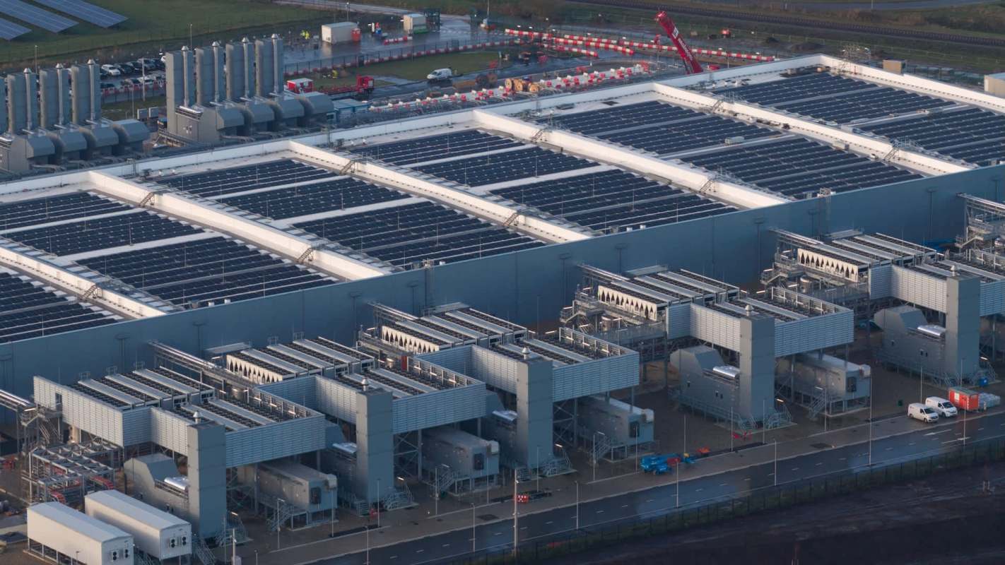 An aerial view of a large data center facility with solar panels and multiple energy generation units.