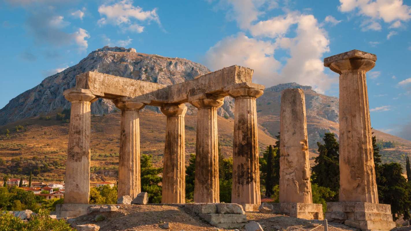 Ancient stone columns situated in front of a mountainous landscape.