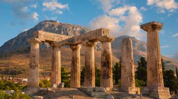 Ancient stone columns situated in front of a mountainous landscape.