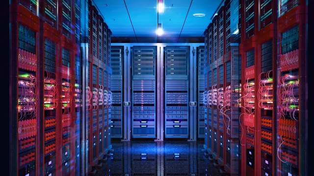 A data center corridor lined with illuminated server racks and colorful cables.