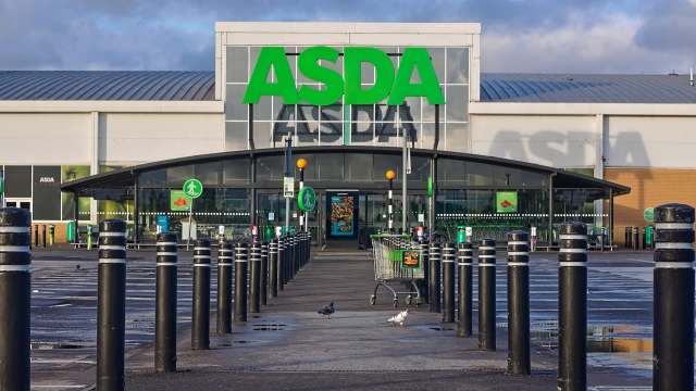 An ASDA supermarket entrance with black bollards and a shopping cart in the foreground.