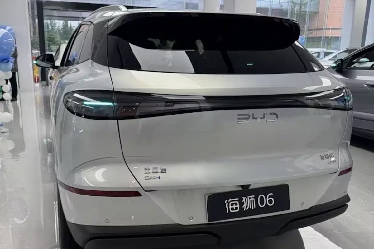 A white BYD car model 06 displayed indoors with sleek lines and modern design features.