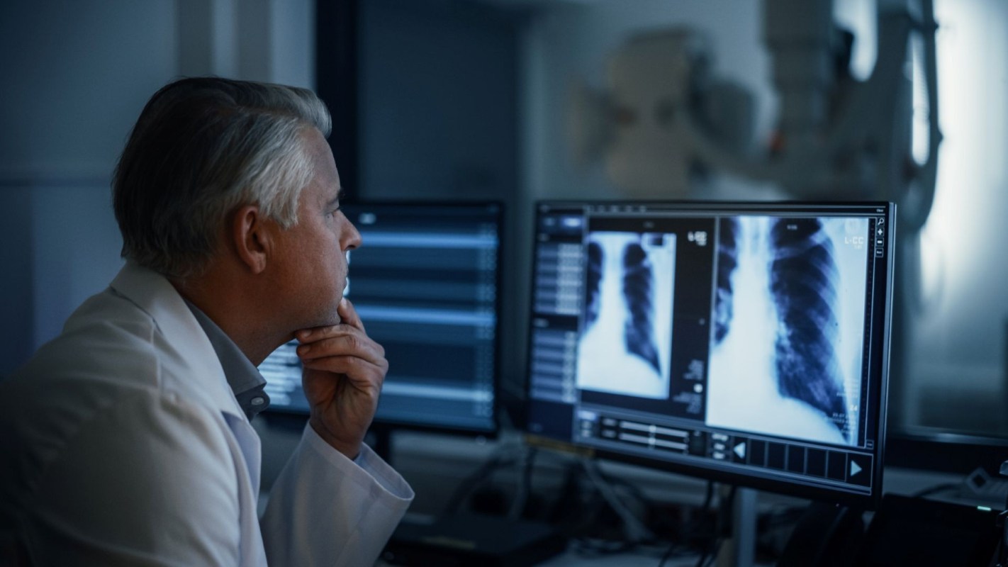 A doctor looking at chest x-rays in a lab.