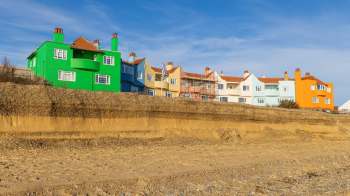 Colorful houses overlooking a sandy beach under a clear sky.