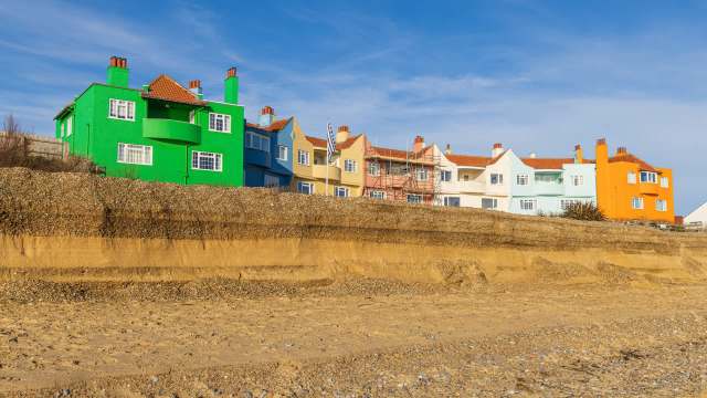 Colorful houses overlooking a sandy beach under a clear sky.