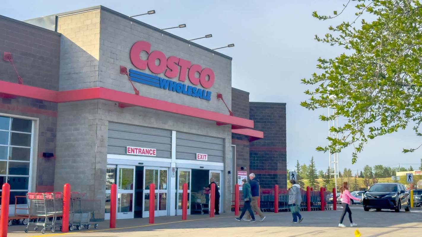 Shoppers entering and exiting a Costco Wholesale on a sunny day.