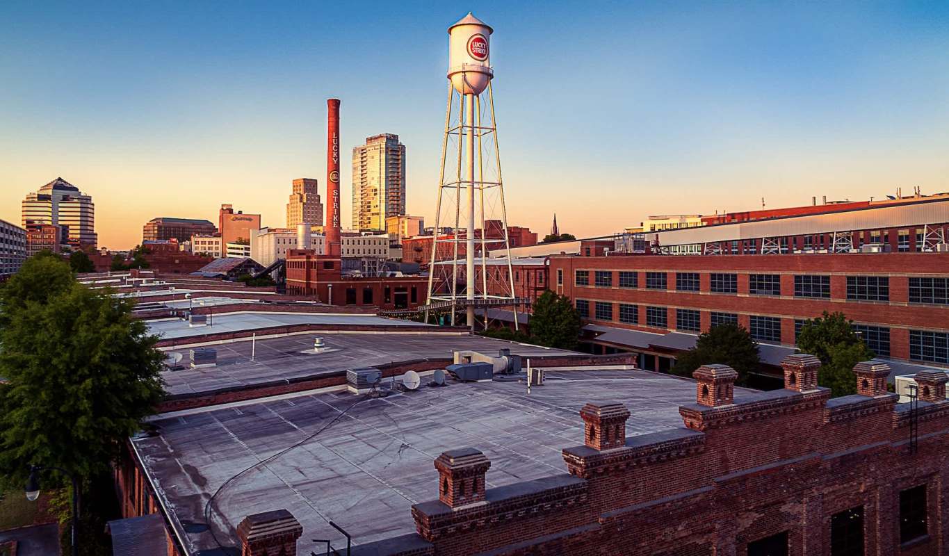 A city skyline featuring a water tower and historic buildings at sunset.