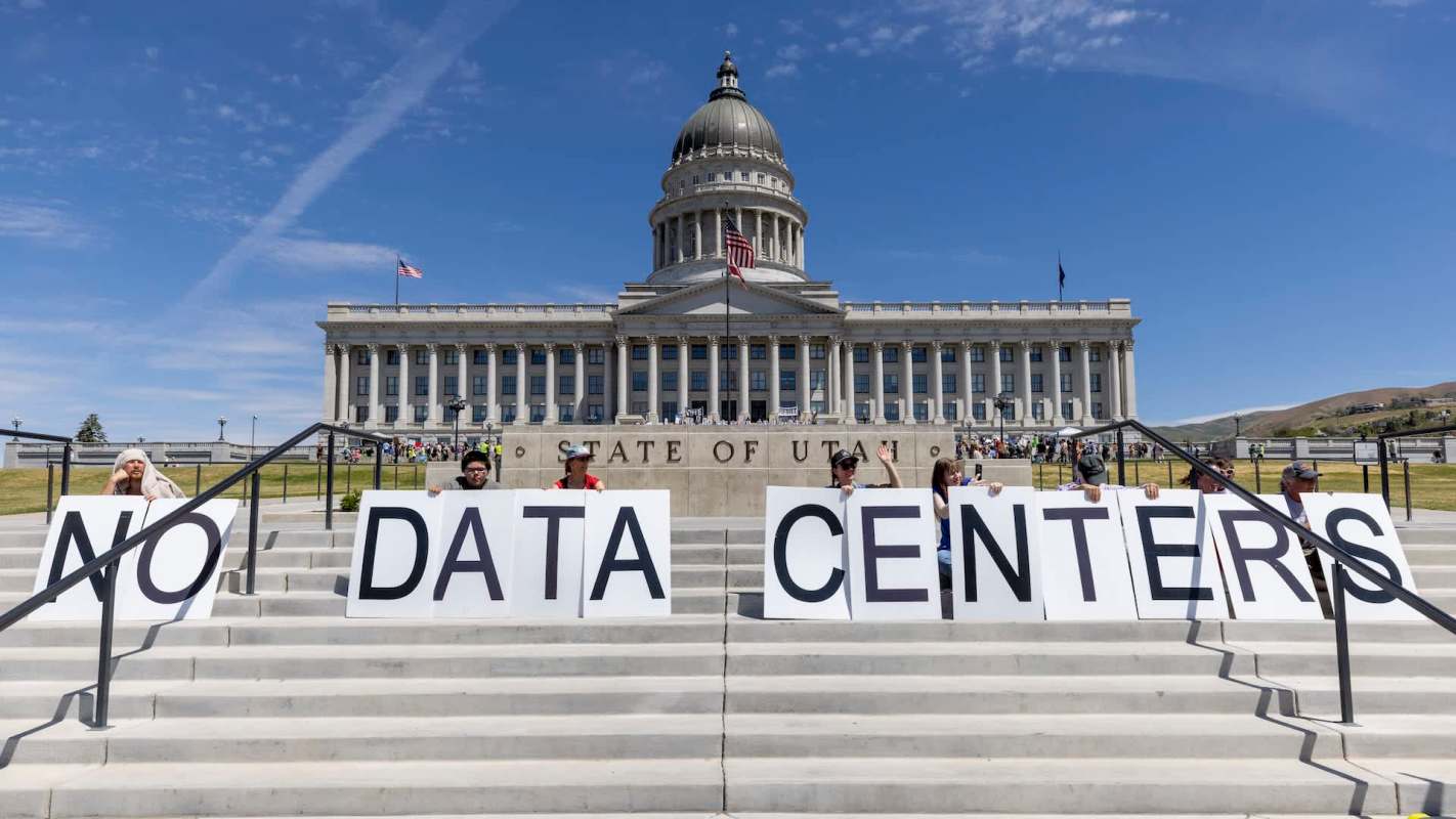 A group of protesters holding signs that read "NO DATA CENTERS" outside the Utah State Capitol building.