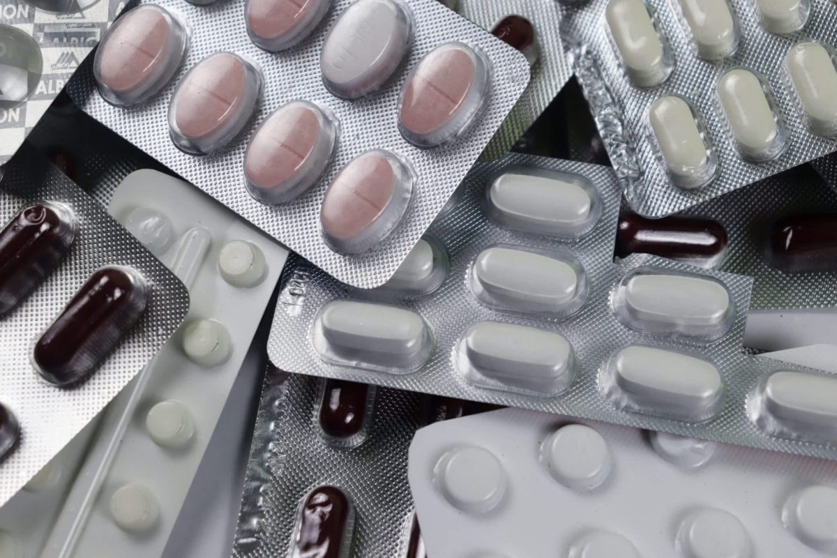 A collection of various blister packs containing different colored pills and capsules.