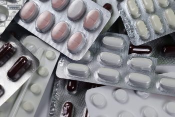 A collection of various blister packs containing different colored pills and capsules.