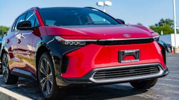 A red and black Toyota SUV is parked, showcasing its sleek front design and modern headlights.