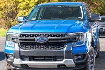A front view of a blue Ford Ranger pickup truck parked in a scenic outdoor setting.