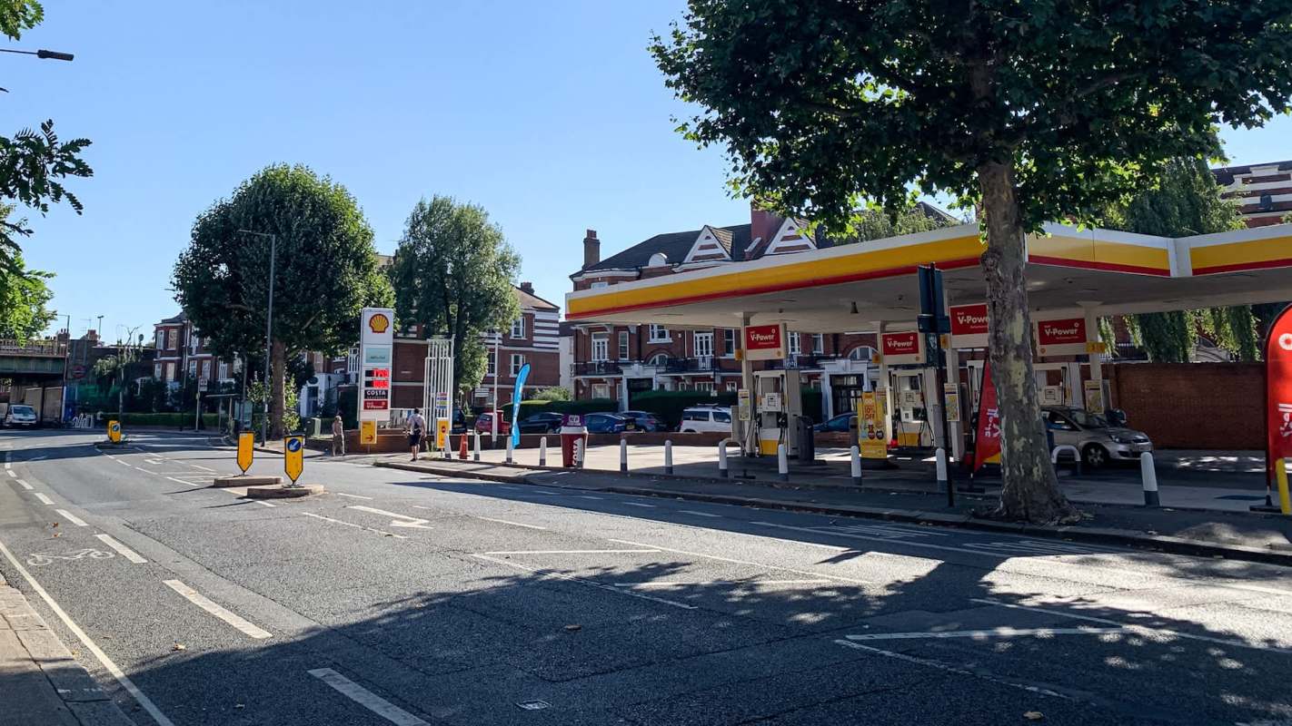 A Shell gas station on the side of a road.