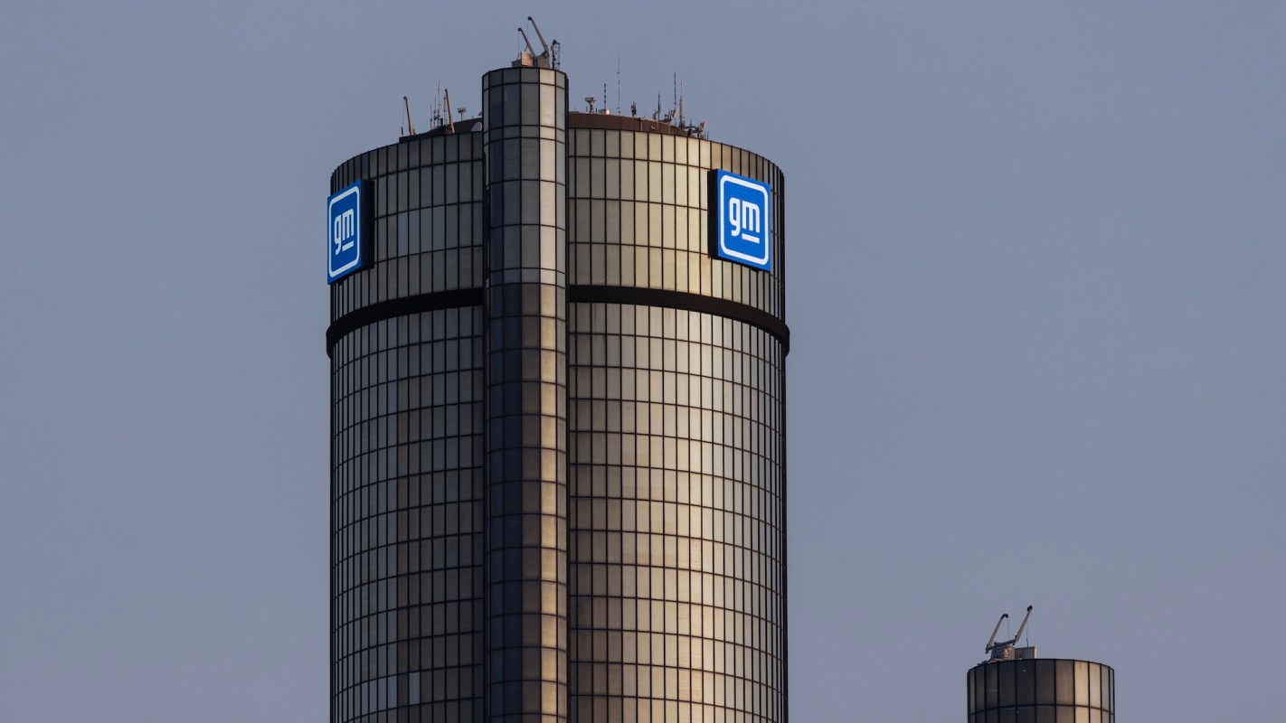 A close-up of the General Motors headquarters tower, featuring large illuminated GM logos.
