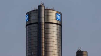 A close-up of the General Motors headquarters tower, featuring large illuminated GM logos.
