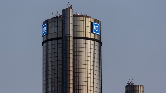 A close-up of the General Motors headquarters tower, featuring large illuminated GM logos.