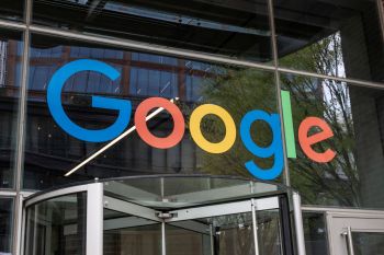 A close-up view of the Google logo displayed on the entrance of a modern building.