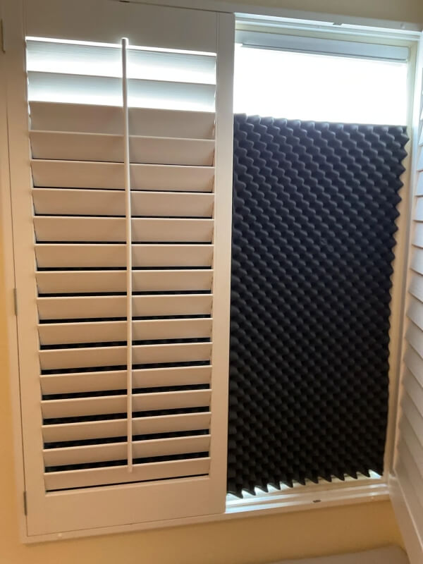 A black piece of acoustic foam in a window to block the sun.