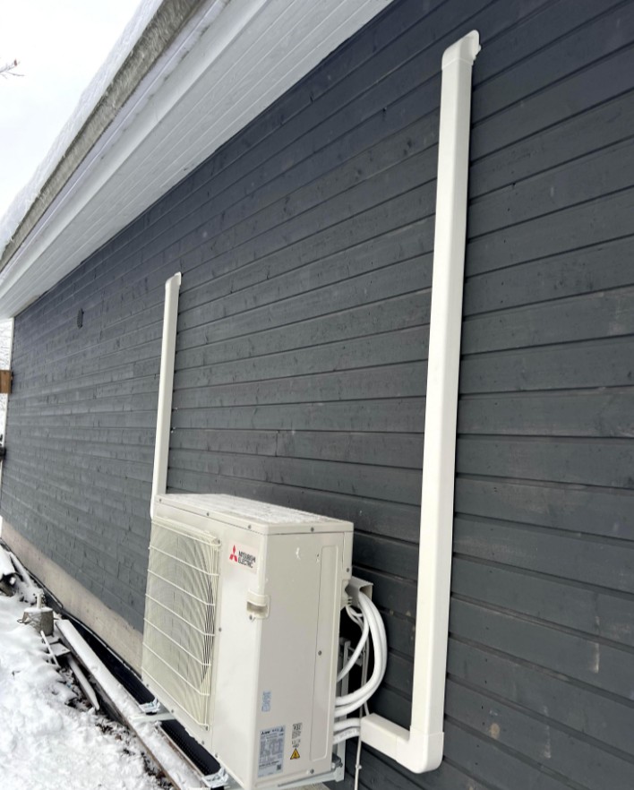 An outdoor HVAC unit surrounded by snow.
