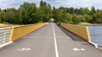 A wide pedestrian and cycling bridge with yellow railings.
