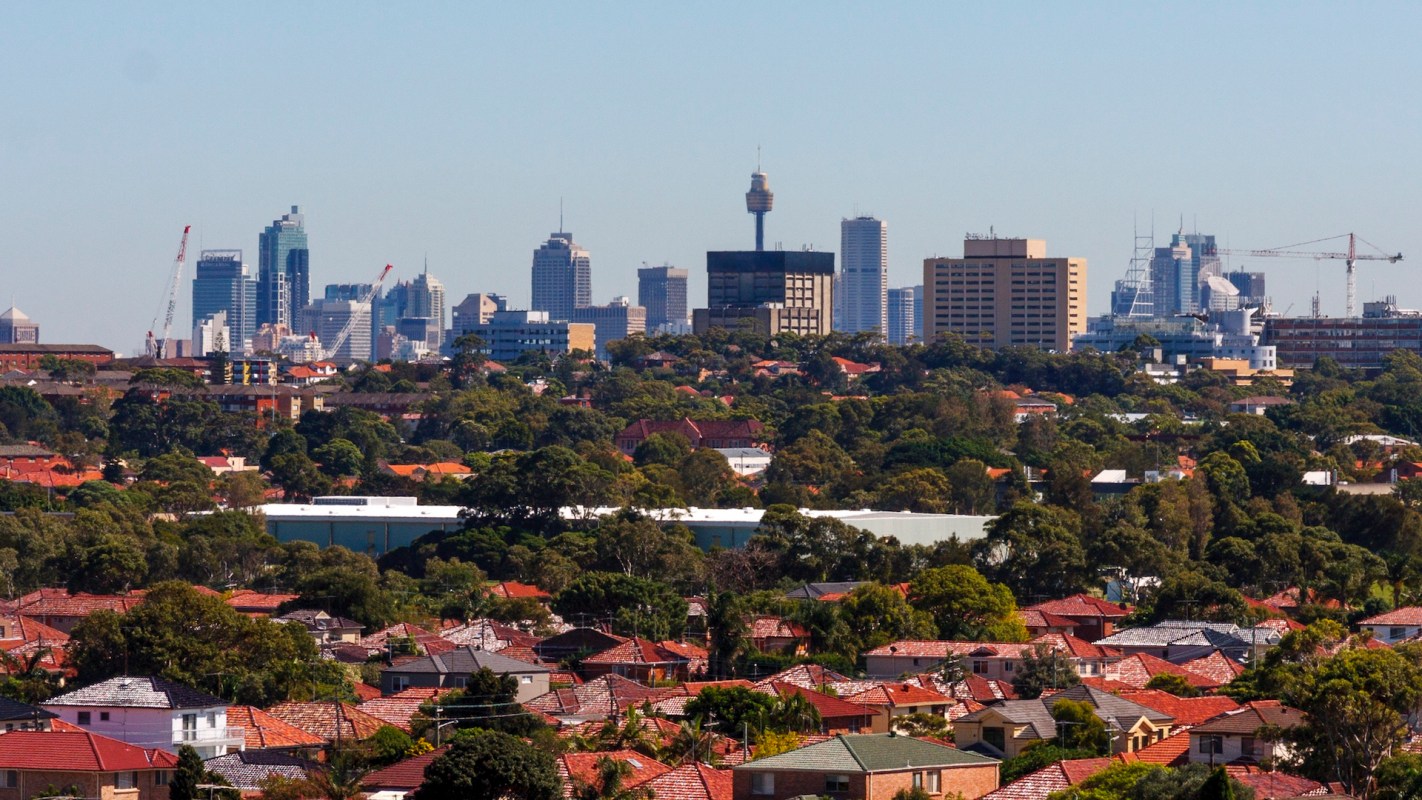 A panoramic view of a city skyline in Sydney, Australia, with modern buildings and greenery in the foreground.