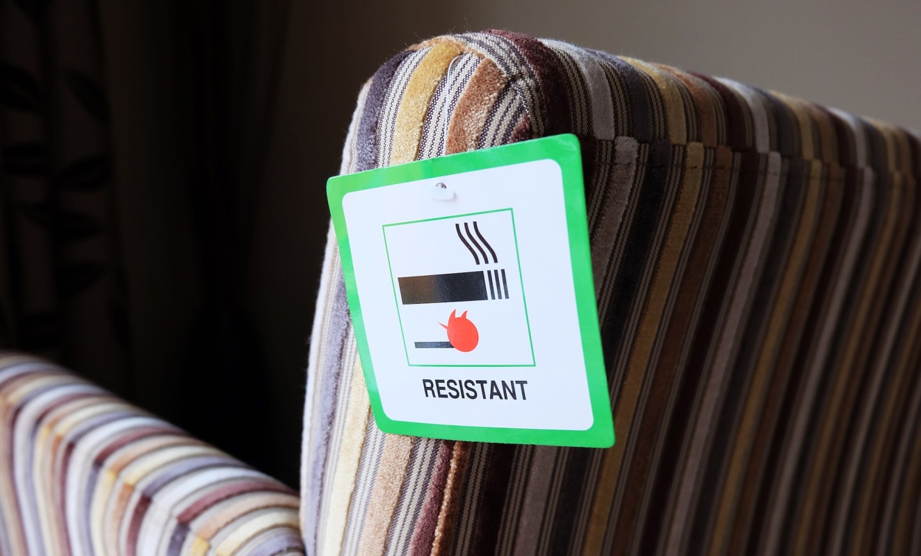 A striped sofa with a label indicating it is fire-resistant.