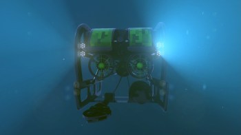A robotic submersible with green accents and lights is illuminated underwater.