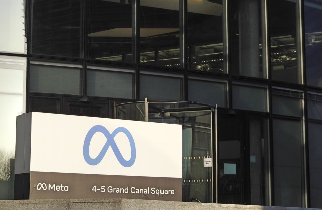 A sign for Meta at 4-5 Grand Canal Square, featuring a blue logo and a revolving door.