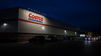 The exterior of a Costco Wholesale store illuminated at night.