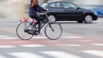 A person rides a bike on a street.